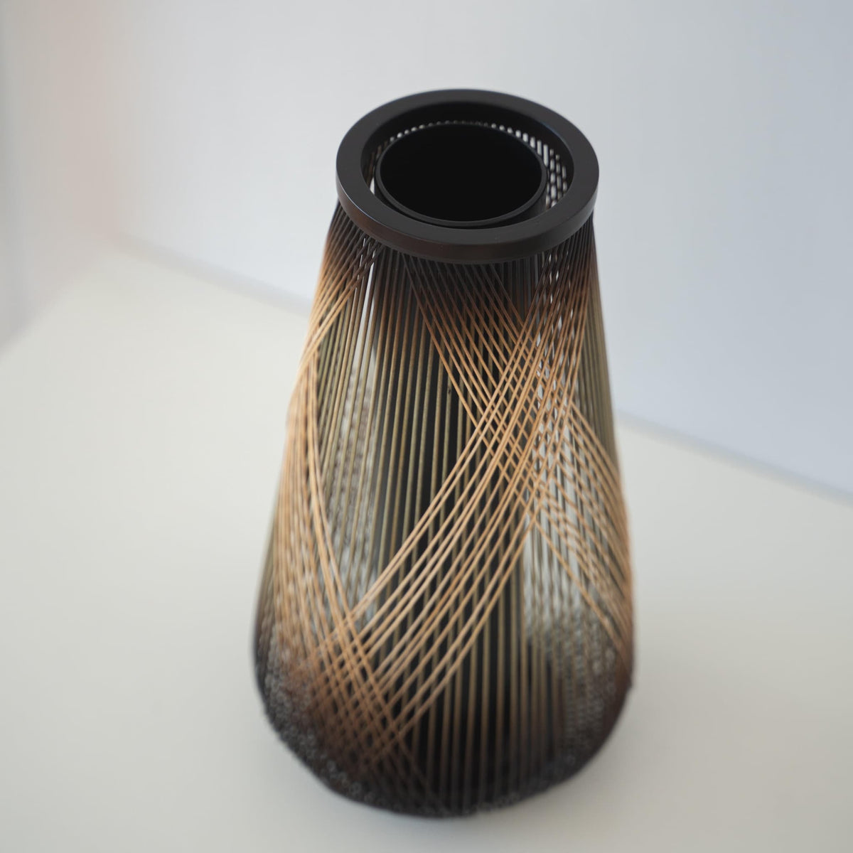 Håndlavet japansk bambusvase, omhyggeligt fremstillet af dygtige håndværkere ved hjælp af traditionelle bambusvævningsteknikker, der viser bambusens naturlige skønhed og elegance.