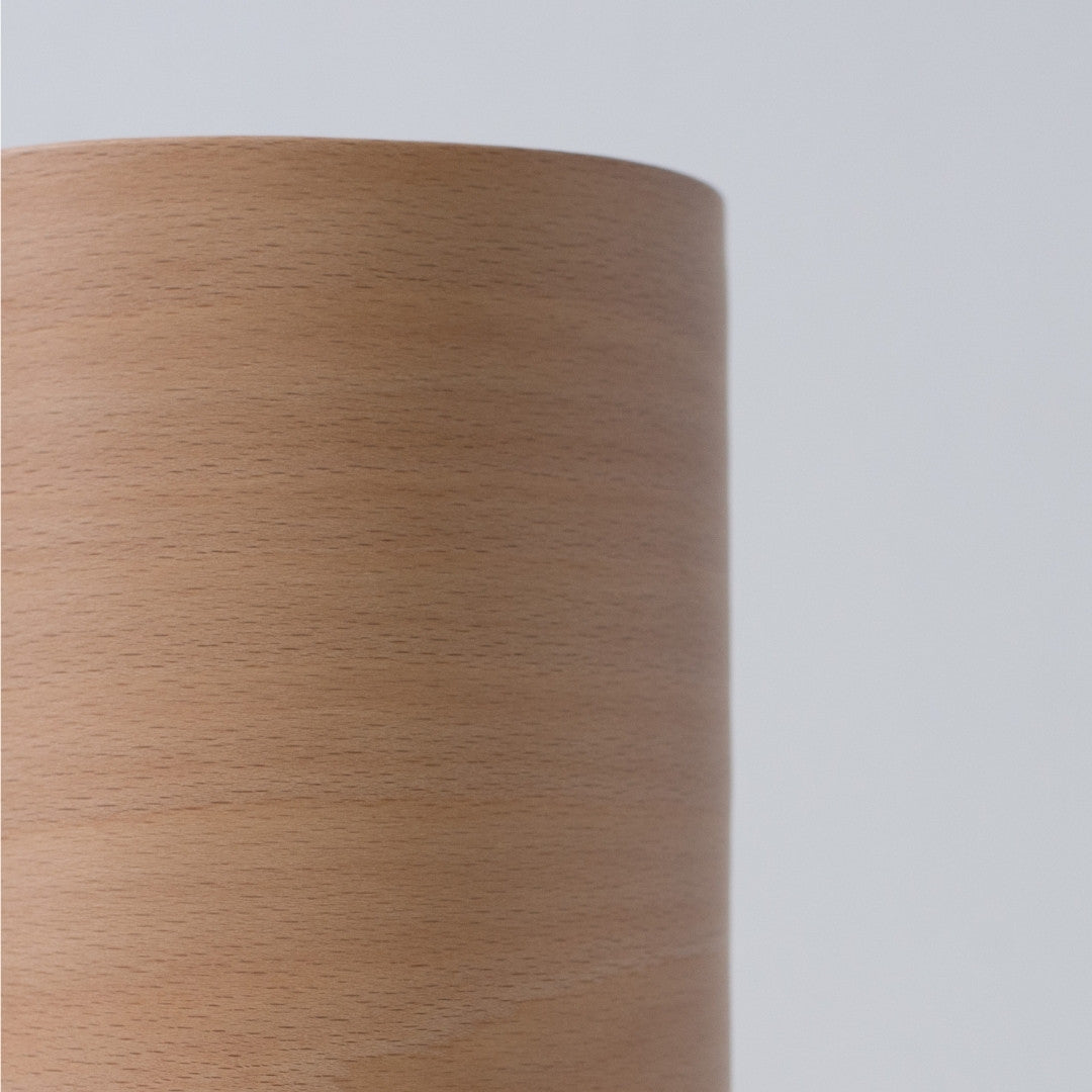 Gros plan d'une lampe de salon japonaise montrant le grain fin du bois et un abat-jour incurvé en hêtre BUNACO.