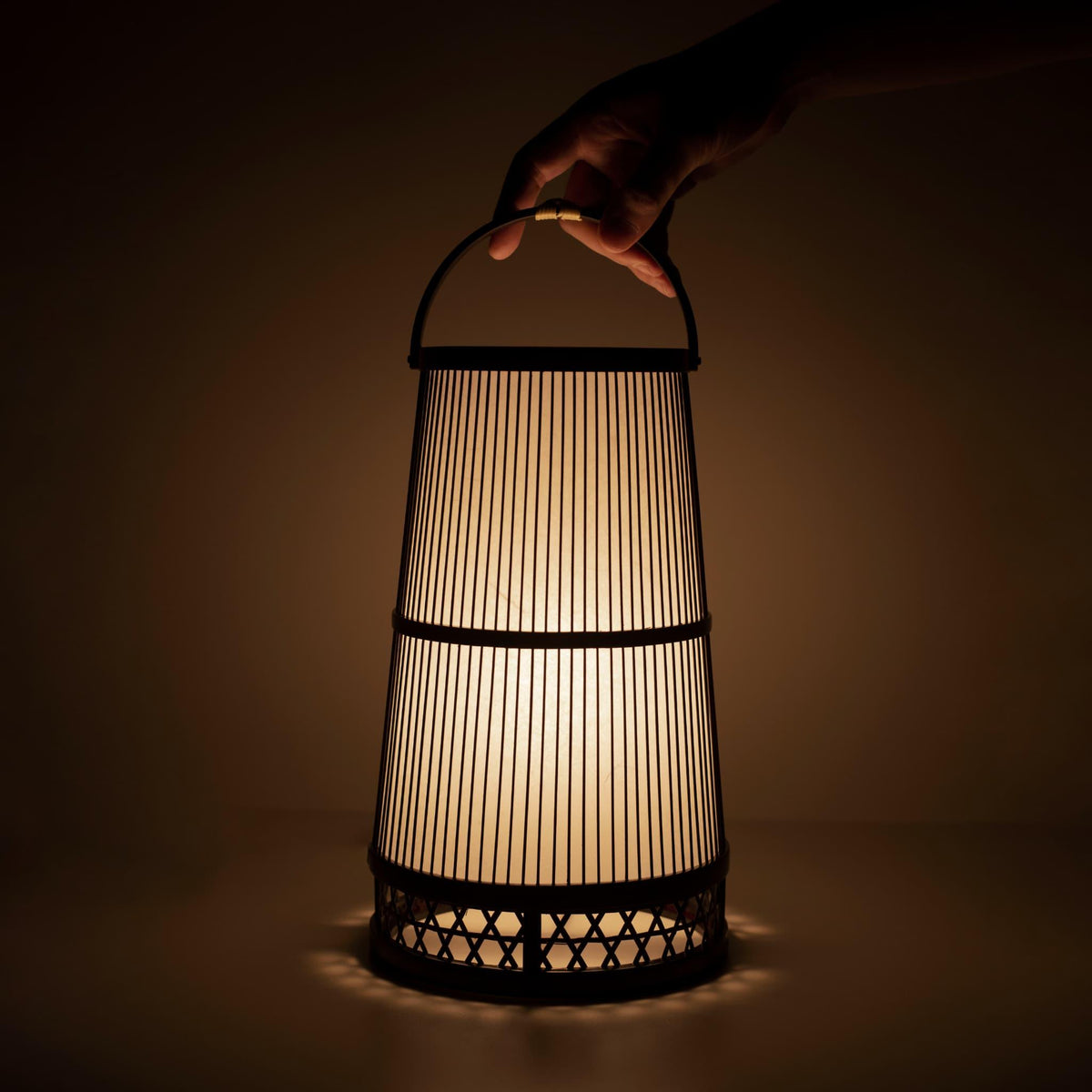 Hånd, der holder en traditionel japansk bambuslampe, håndlavet i Shizuoka med 800 år gamle teknikker.