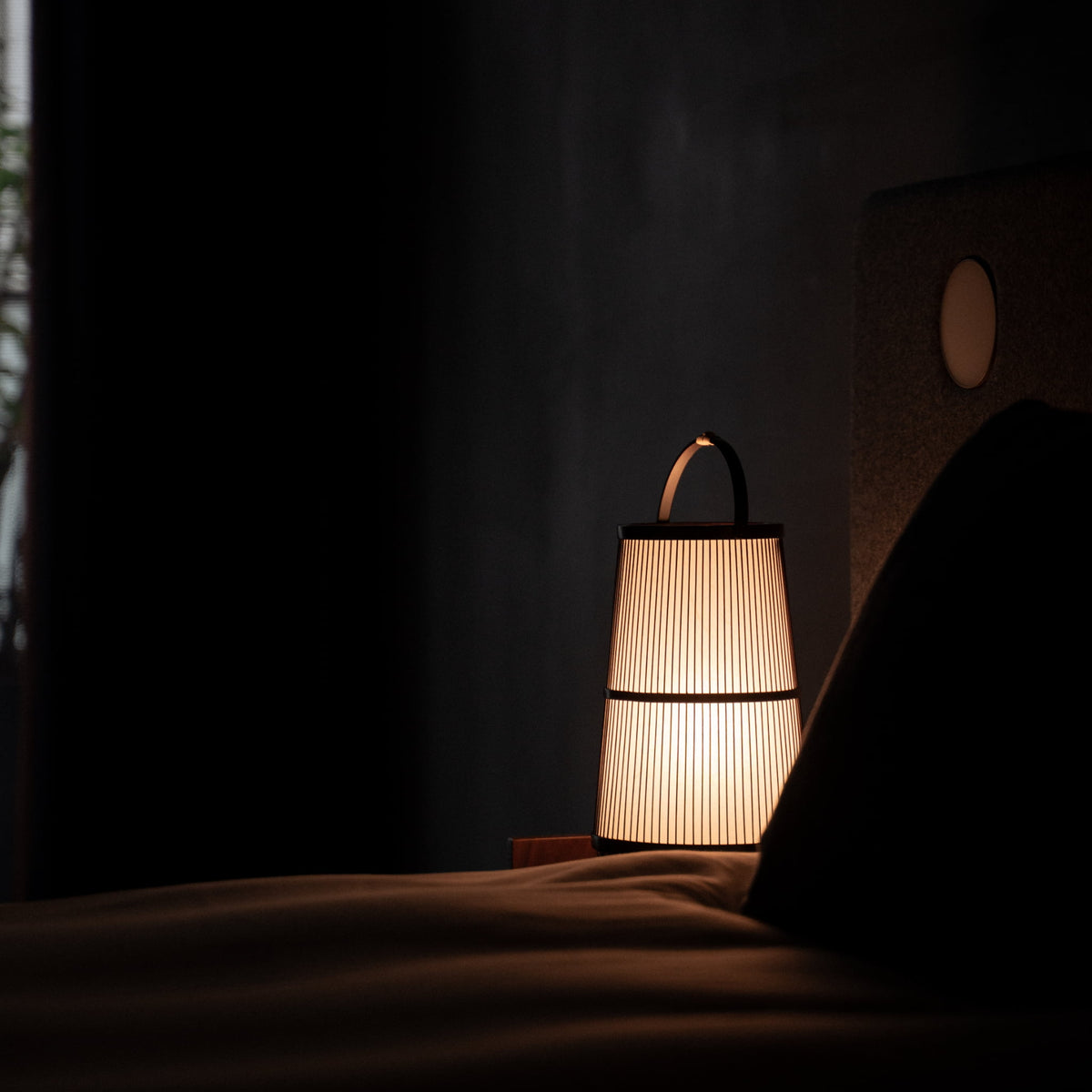 japansk bambuslampe placeret på et natbord i et soveværelse i Japandi-stil.