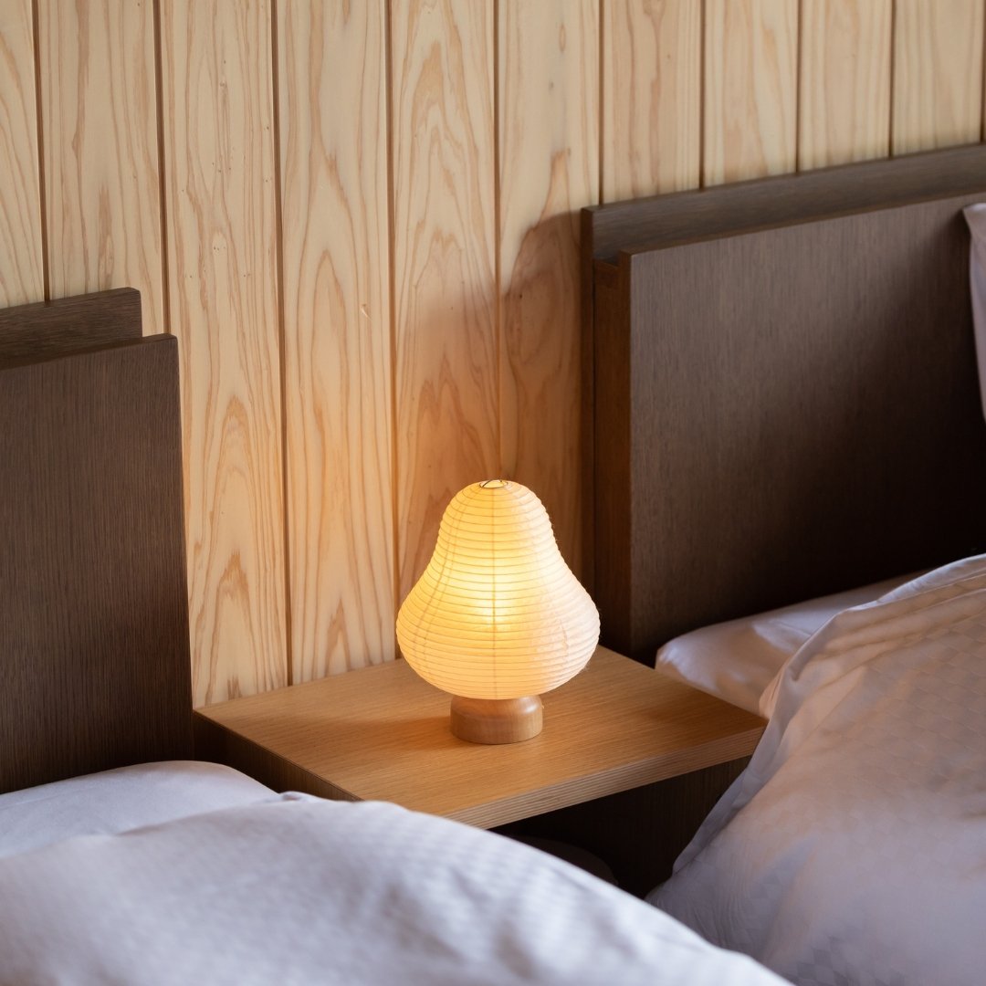 "Lampe de table japonaise en papier « Montagne » sur une table de chevet"