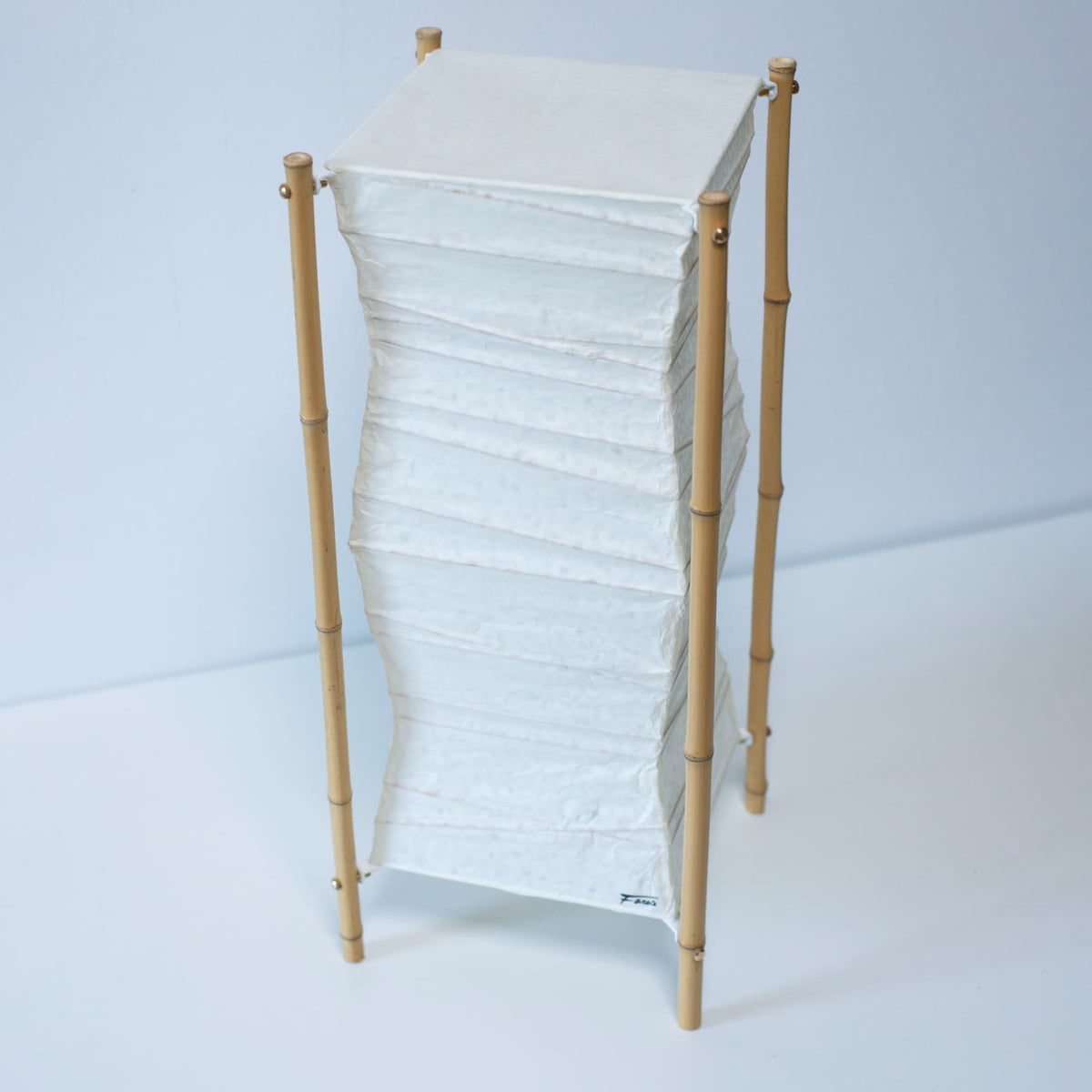 A Japanese paper floor lamp on white background.