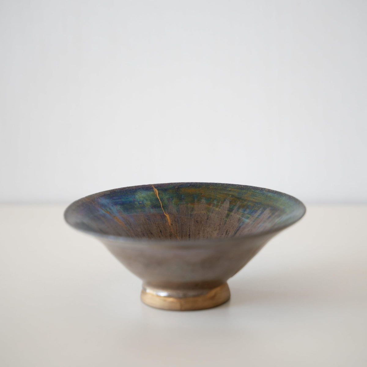 Vue de côté du bol Kintsugi "Iris Rose" sur fond blanc
