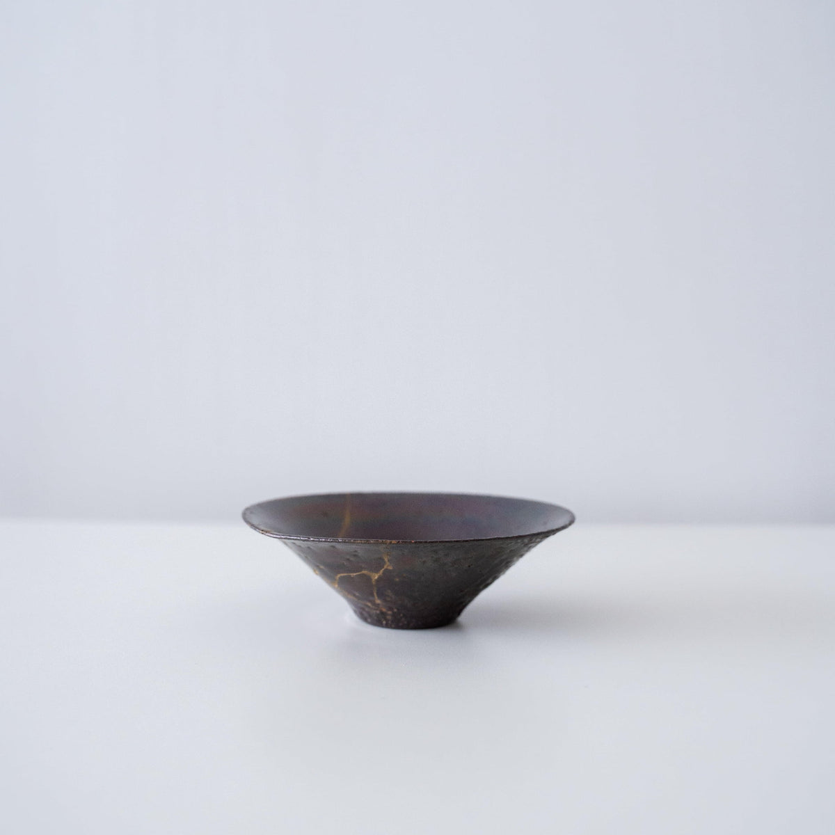 Seitenansicht einer Kintsugi-Schale „Purple Nebula 01“ auf weißem Hintergrund