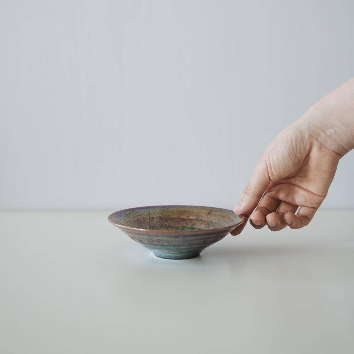 Main tenant une coupe Kintsugi « Supernova », montrant sa taille et comment elle tient dans la main
