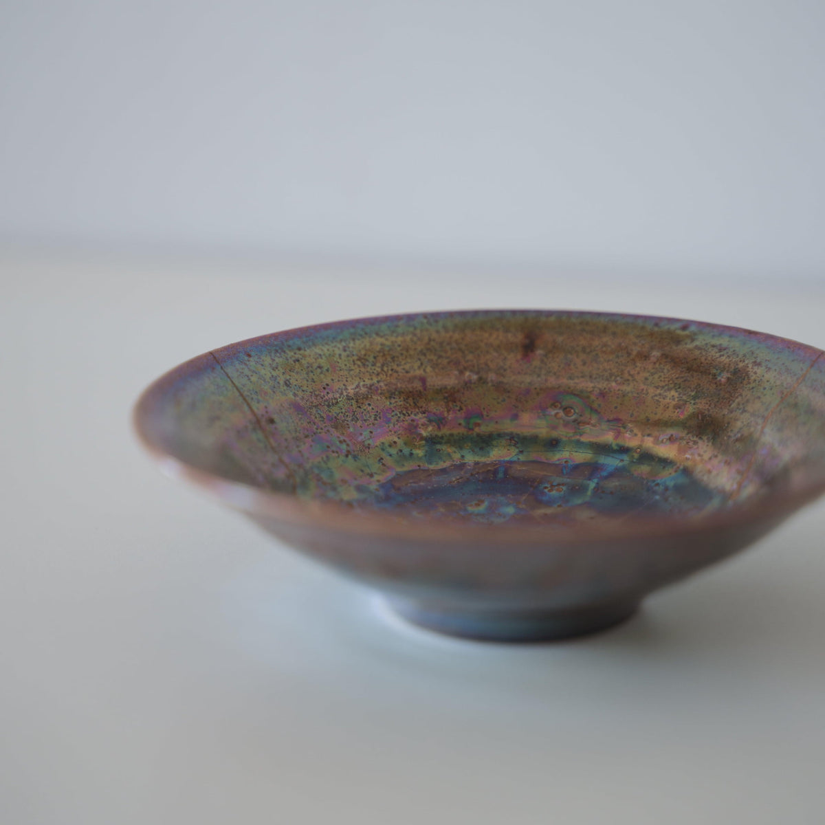 Gros plan sur le côté du bol Kintsugi "Supernova", mettant en valeur les réparations Kintsugi complexes