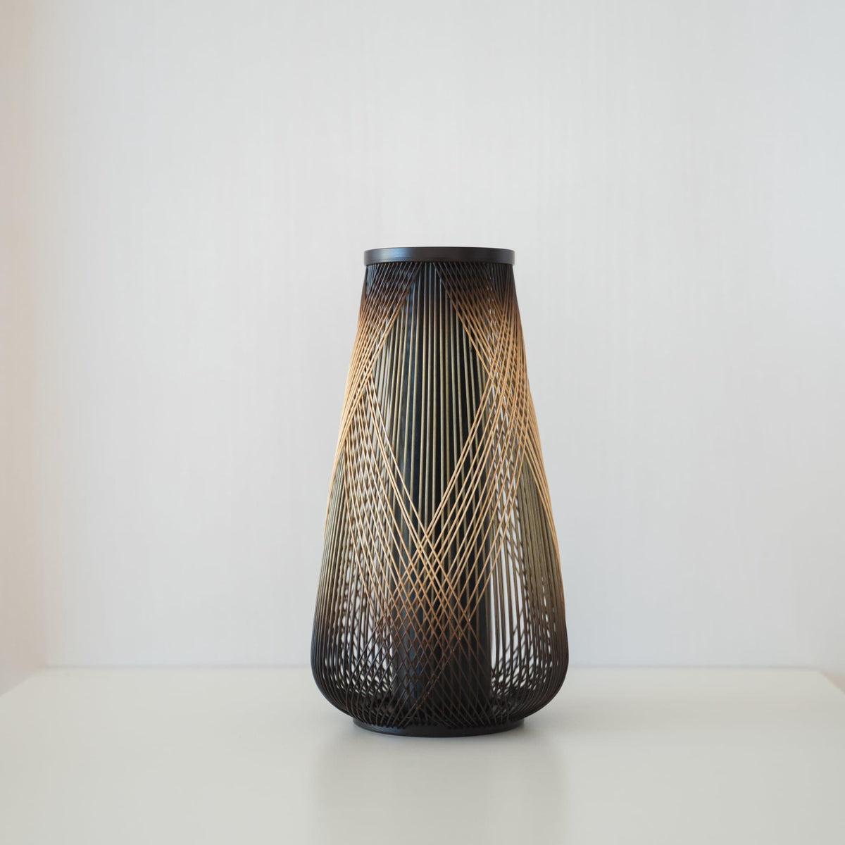 Håndlavet japansk bambus Ikebana-vase, omhyggeligt fremstillet af dygtige håndværkere ved hjælp af traditionelle bambusvævningsteknikker, der viser bambusens naturlige skønhed og elegance.