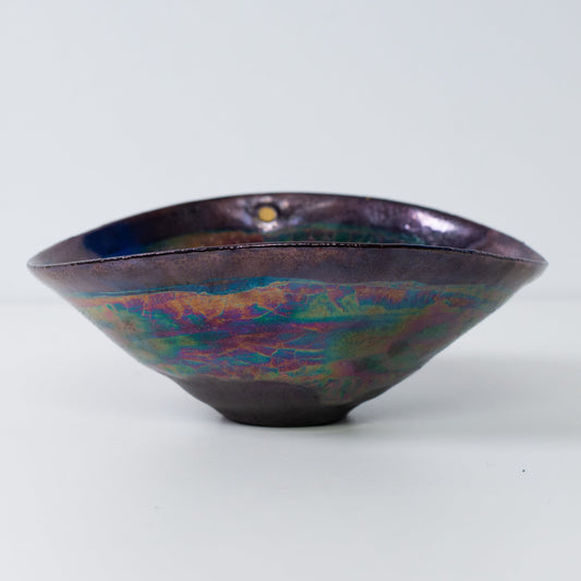 Japanese Kintsugi pottery bowl side view with metallic glaze and gold-filled cracks