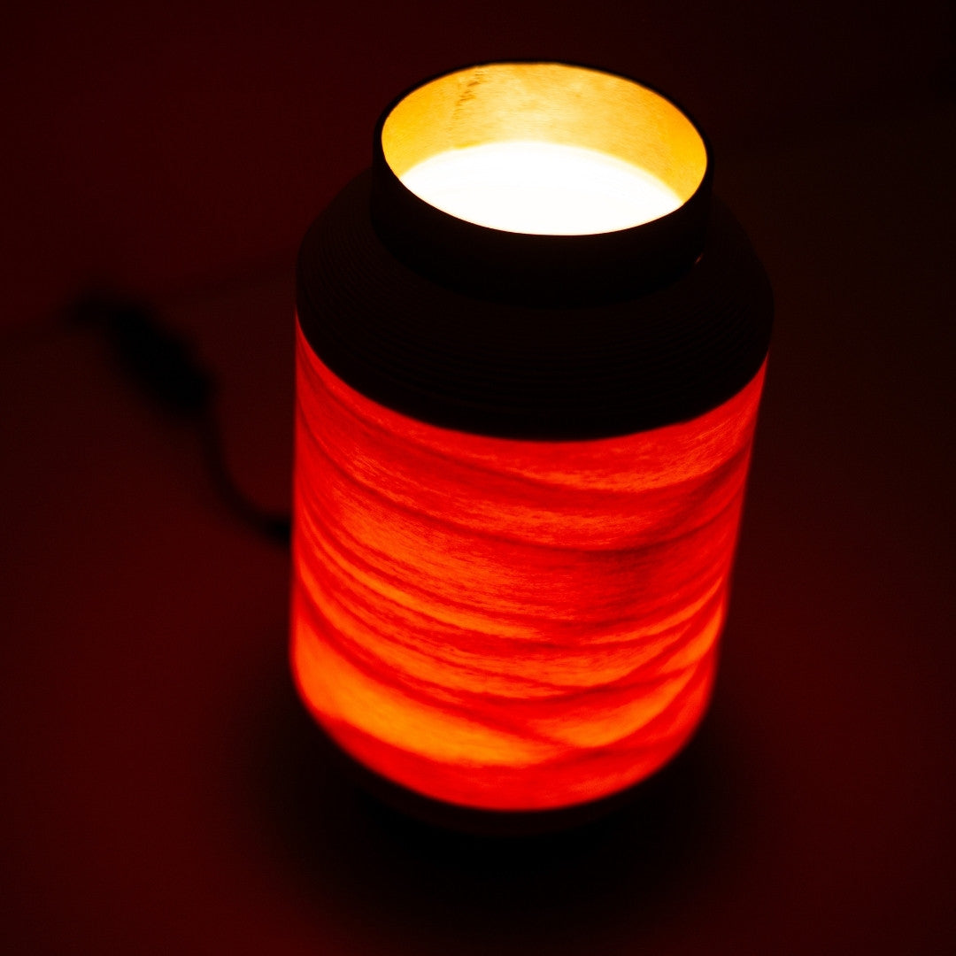 Bovenaanzicht van Japanse tafellamp, vervaardigd door BUNACO, met sfeerverlichting die door de houten kap filtert.
