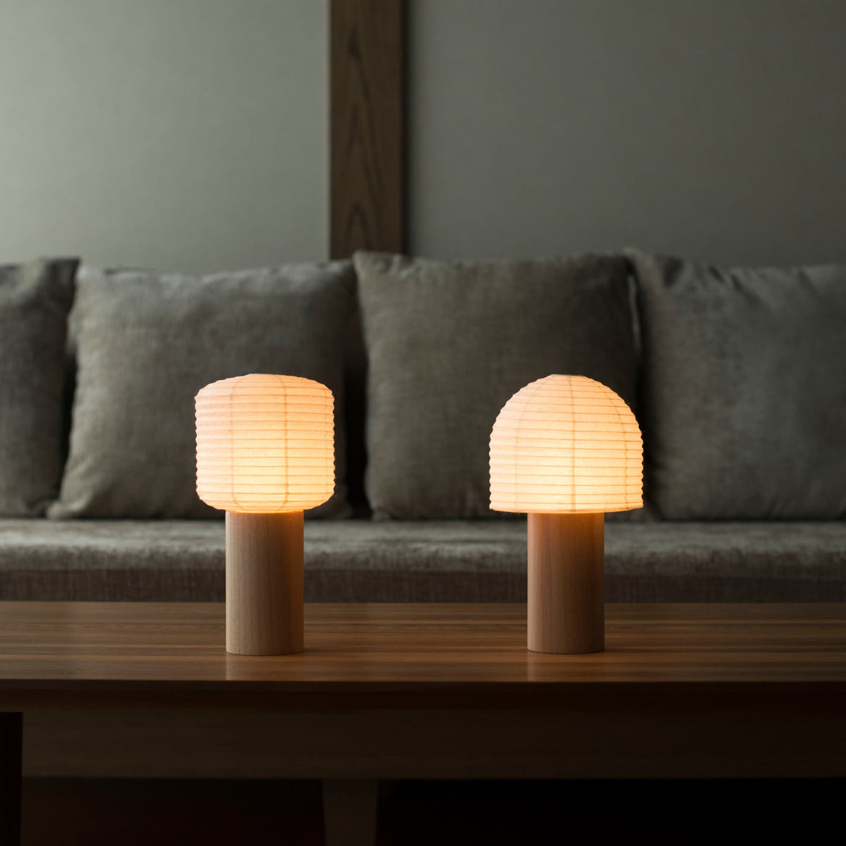Twee draagbare Japanse papieren lampen met warm licht, geplaatst op een tafel in een traditionele Japanse kamer.