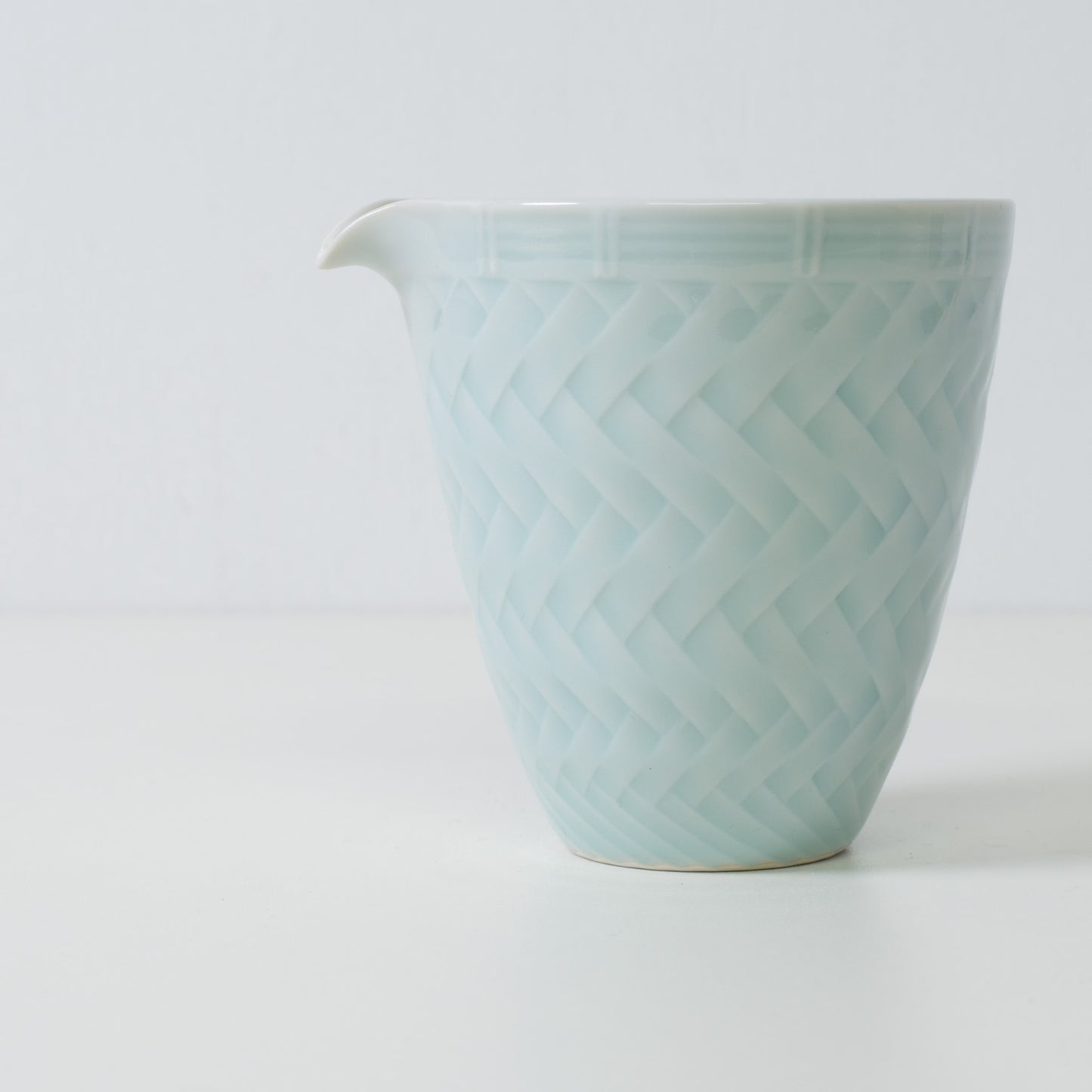 Carafe à saké en porcelaine tressée, bleu glacier - Gros plan sur une carafe à saké japonaise mettant en valeur le motif tressé