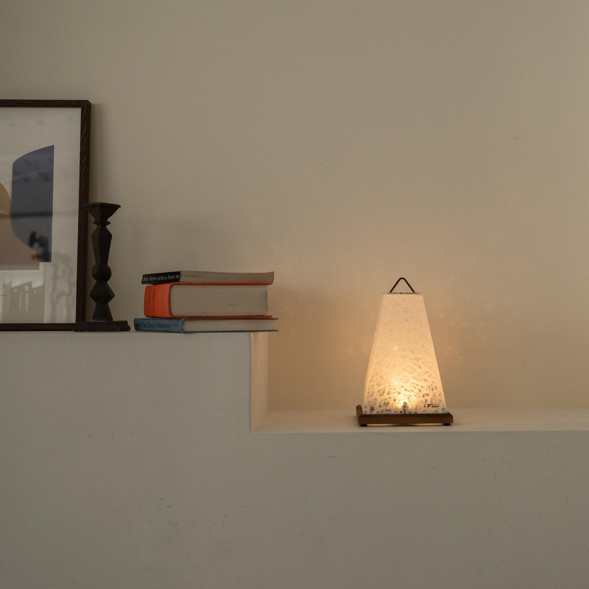 Lit Japanse papieren tafellamp "Mini Akari" Wit die een warme gloed werpt als accentlamp op een witte Japandi woonkamer console.