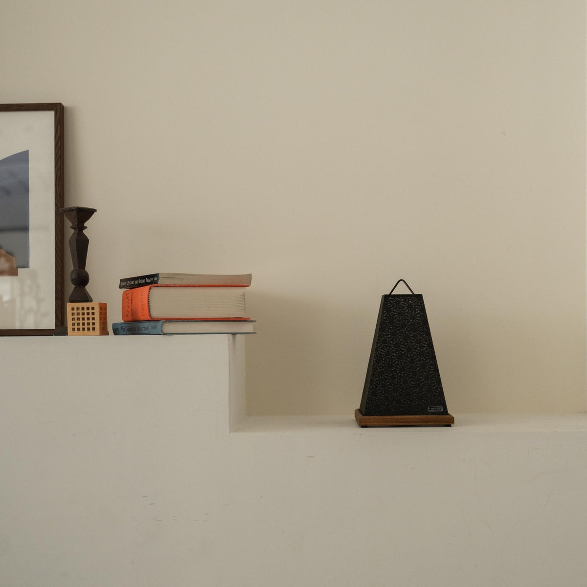Onverlichte Japanse papieren tafellamp "Mini Akari" Zwart geplaatst op een witte console tafel in een minimalistische Japandi woonkamer.