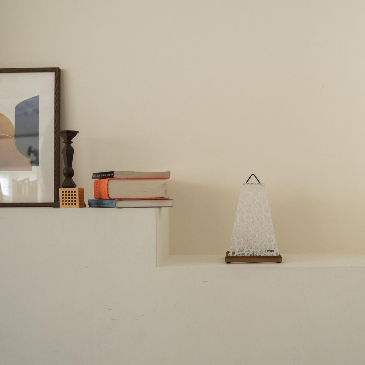 Onverlichte Japanse papieren tafellamp "Mini Akari" Wit geplaatst op een witte console tafel in een minimalistische Japandi woonkamer.
