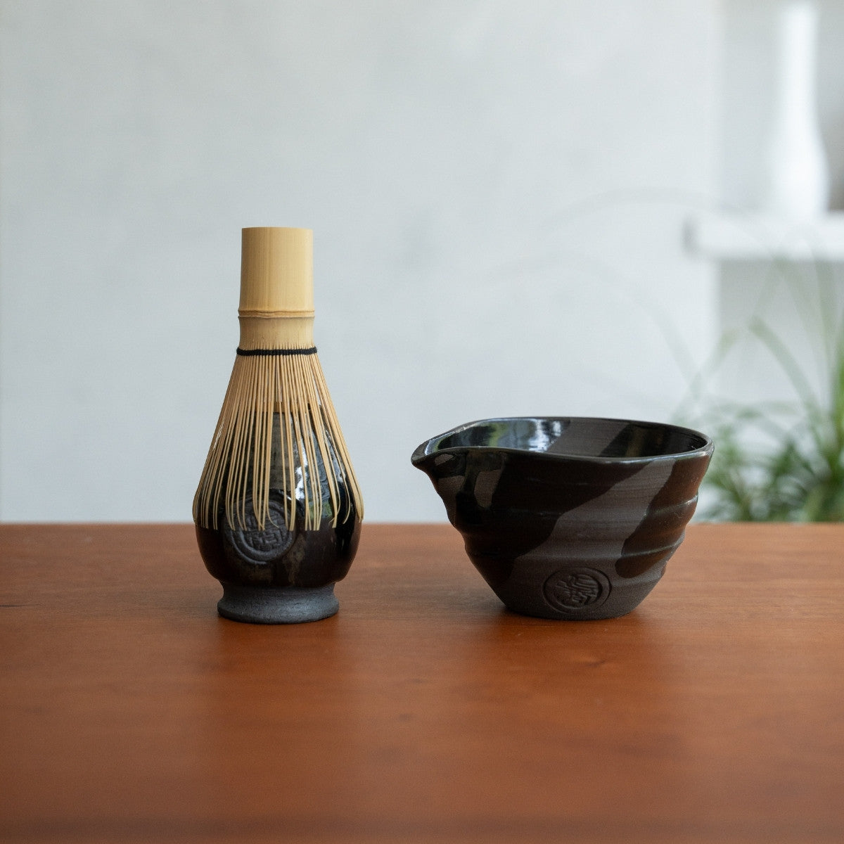 Sumi Black Matcha-Schale mit Ausguss und japanischer Matcha-Besenhalter auf einem Holztisch für ein authentisches Matcha-Ritual