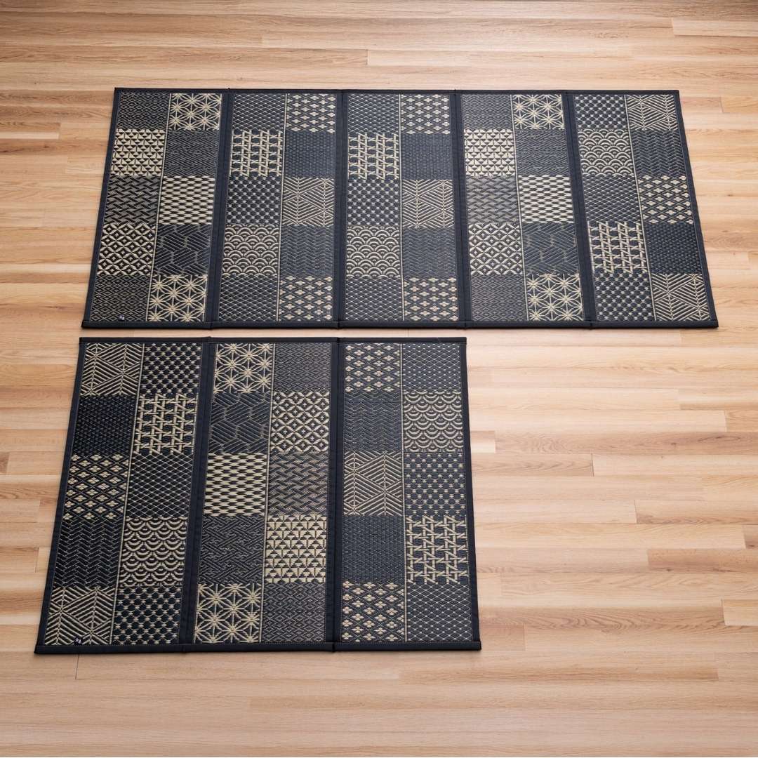 Sorte Edokomon tatami-madrasser i 3- og 5-felts foldbare størrelser lagt ud på et trægulv til moderne japansk indretning.
