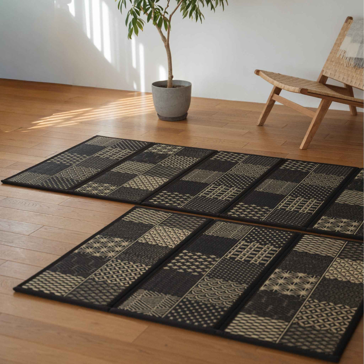 Detaljeret visning af edokomon tatami-måtter på et gulv, der viser unikke geometriske snit og tekstur af sort sivgræs.