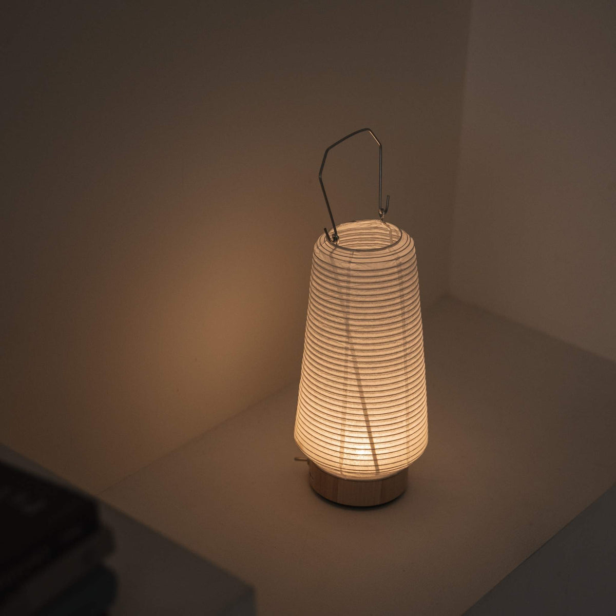 "Draufsicht einer beleuchteten tragbaren Lampe aus Mino Washi-Papier, die die gerippte Struktur und das warme Licht hervorhebt"