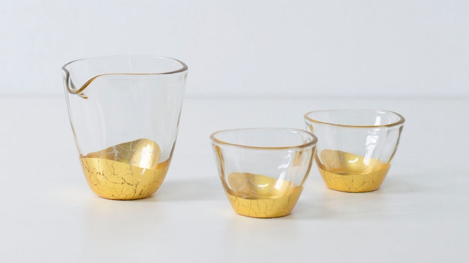 "Ensemble de saké japonais élégant avec motif en feuille d'or, comprenant une bouteille de saké et deux tasses à finition craquelée"