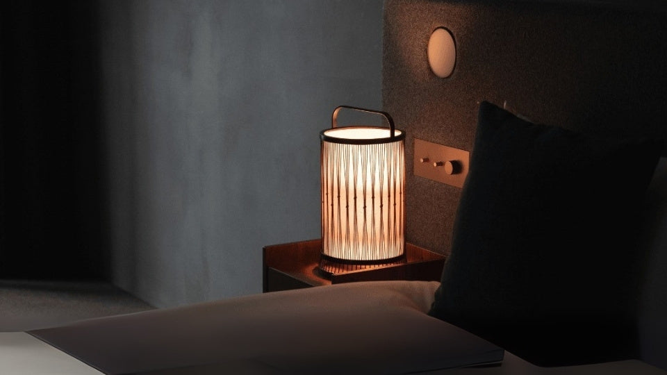 "Eine japanische Bambuslampe auf einem Nachttisch in einem Schlafzimmer im Japandi-Stil."