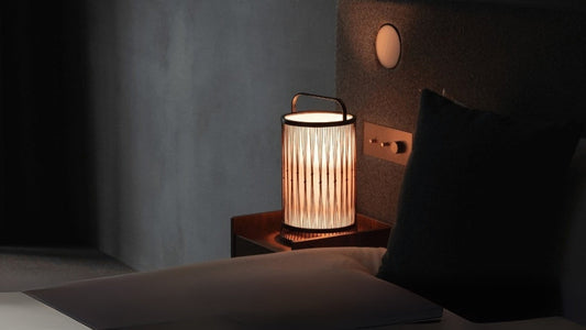 "Eine japanische Bambuslampe auf einem Nachttisch in einem Schlafzimmer im Japandi-Stil."