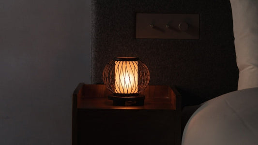 "Japanische Bambus-Tischlampe „Mondhase“ wirft warmes Licht auf einen Nachttisch in einem Schlafzimmer im Japandi-Stil"