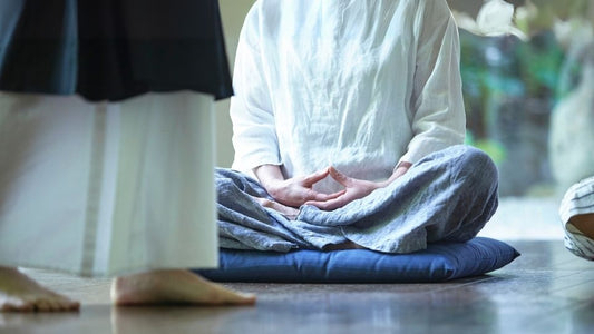 Traditionelles Zazen auf einem Meditationskissen während einer ruhigen Achtsamkeitssitzung in einem Innenraum