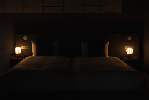"Chambre Japandi avec deux lampes de chevet japonaises en papier sur des tables de chevet"