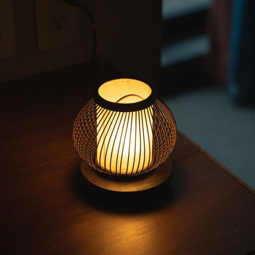 "Une lampe de table japonaise en bambou diffuse une lumière chaude sur une table"