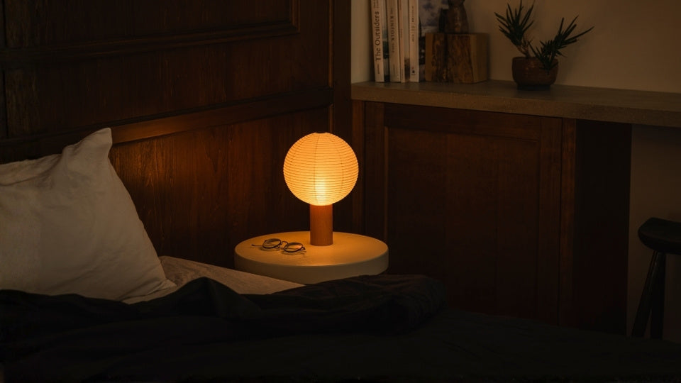 Varm washi japansk bordlampe lyser på et natbord i et japandi-soveværelse, en bærbar lampe perfekt som japansk gave.