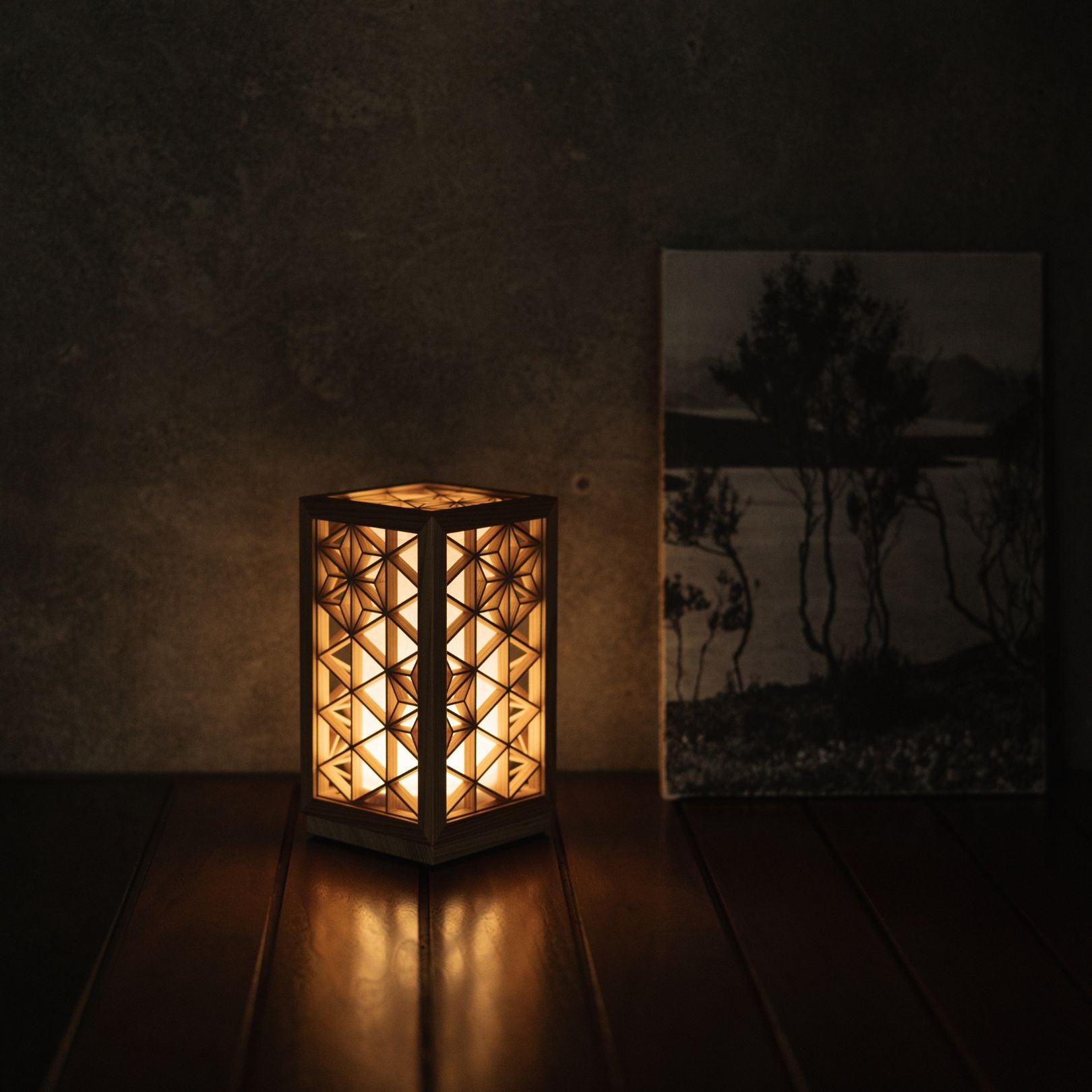 Japanese Kumiko table lamp "Asanoha" on a living room table with a Book.
