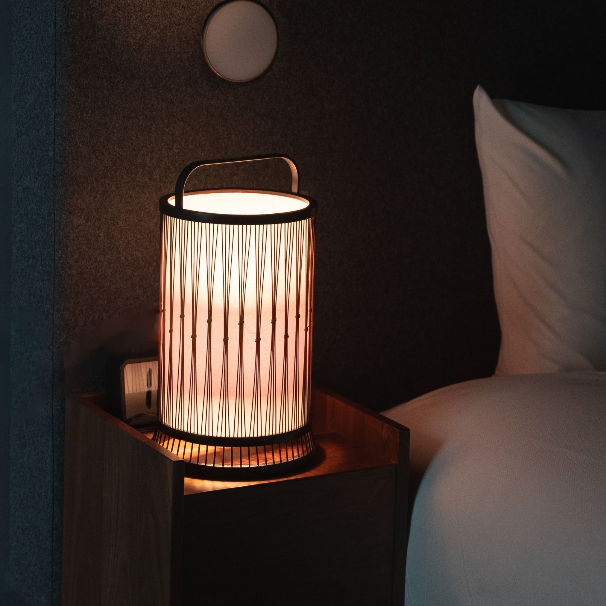 "Eine japanische Bambuslampe auf einem Nachttisch in einem Japandi-Schlafzimmer"