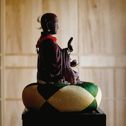 Buddha-statue siddende på Sakae Kinran meditationspude, traditionelt tempeldesign