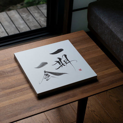 Vue inclinée de dessus d'un panneau avec la calligraphie japonaise 'Ichigo Ichie' sur une table en bois.