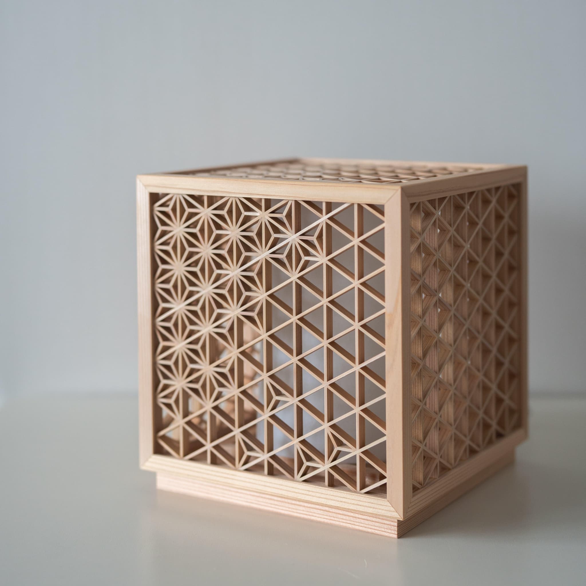 "Lampe sur pied japonaise Kumiko « Asanoha » sur une table blanche"