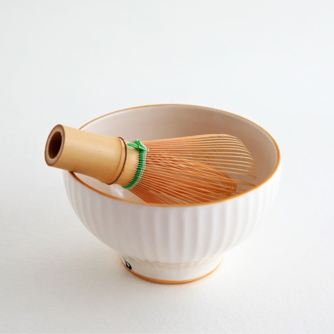 delikat japansk matcha-skål "Waraku" ledsaget af en bambuspisker, der repræsenterer Buzan Kilns kunsthåndværk og den 1.500 år gamle tradition inden for Mino Ware-keramik.