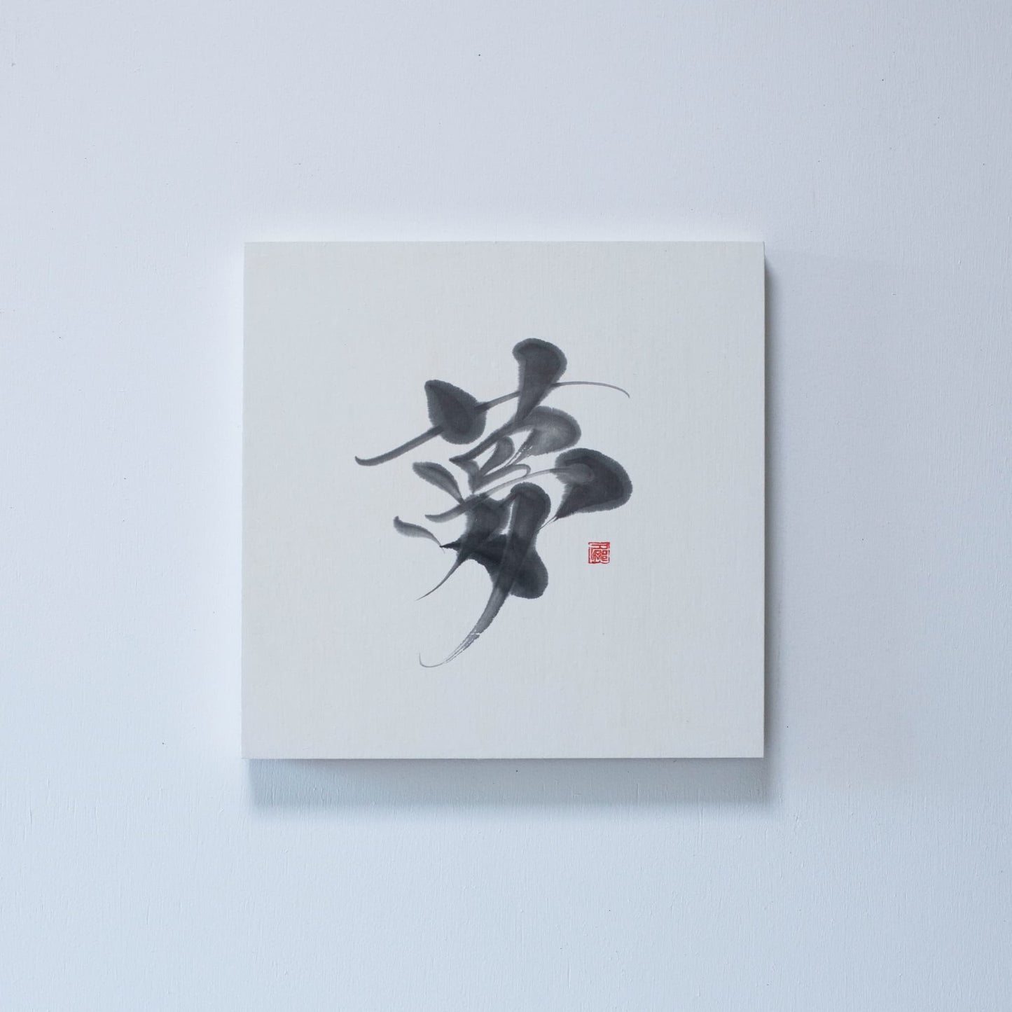 Vierkant paneel met Japanse kalligrafie van het karakter '夢' (droom) op wit rijstpapier, gemonteerd aan een witte muur