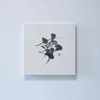 Vierkant paneel met Japanse kalligrafie van het karakter '夢' (droom) op wit rijstpapier, gemonteerd aan een witte muur