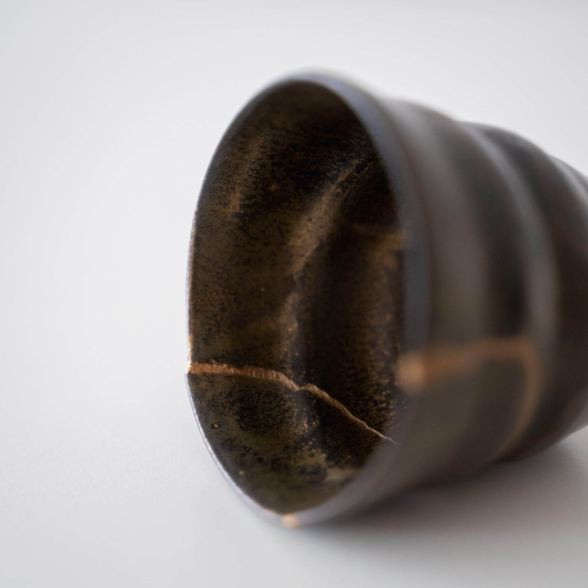 Close-up van Kintsugi-reparatie op een Kintsugi Sake-beker "Thunder Moss"