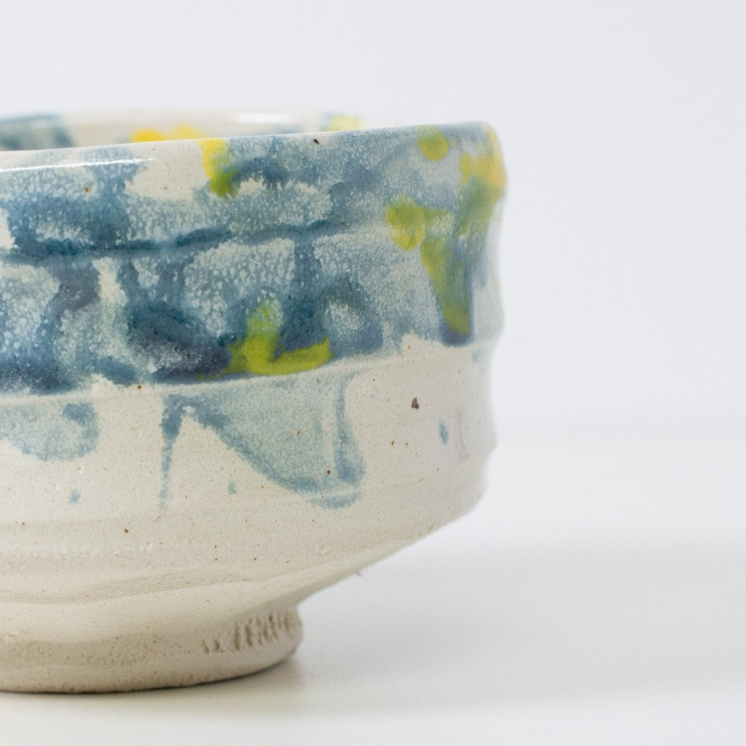 Nahaufnahme der „Splash“ Matcha-Chawan-Schale mit blauer Glasur, die an Wasserspritzer im Sonnenlicht erinnert.