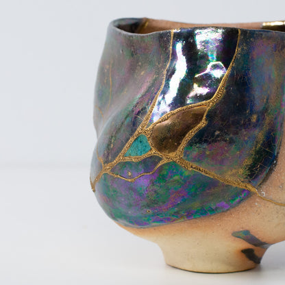 Close-up of Japanese kintsugi matcha bowl showing detailed gold lacquer repairs