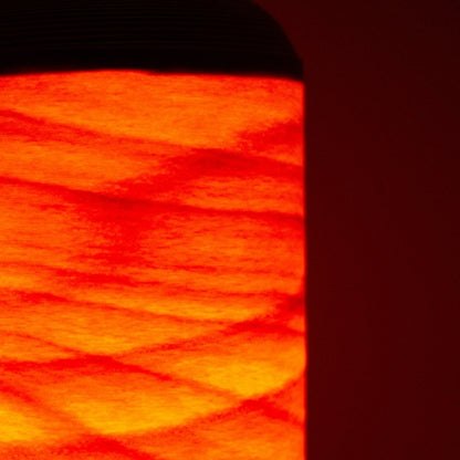 Close-up van een Japanse woonkamerlamp die als een vreugdevuur gloeit door dunne beukenhouten lamellen.