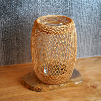 delikat, kokonformet japansk ikebana-vase lavet af bambus, med smukt flettede bambusstrimler.