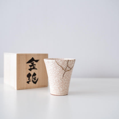 Kintsugi-repareret hvid kop og gaveæske af paulownia-træ, der symboliserer den japanske æstetik med at finde skønhed i ufuldkommenhed.