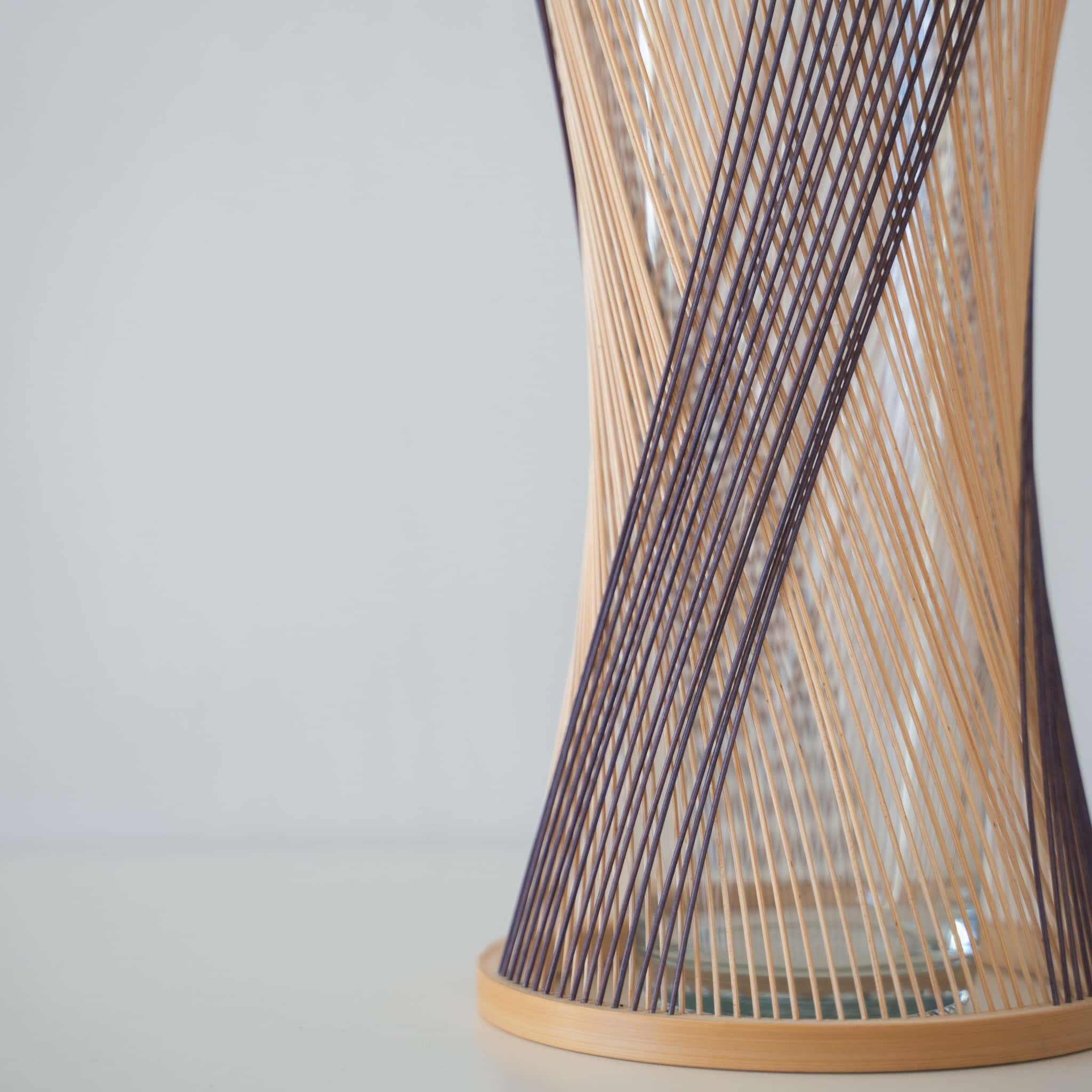 Detail of handcrafted Japanese bamboo Ikebana vase, meticulously crafted by skilled artisans using traditional bamboo weaving techniques, showcasing the natural beauty and elegance of bamboo.