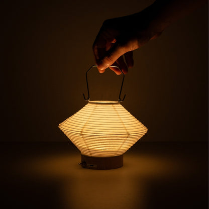 Hand holding diamond-shaped Japanese paper table lamp RIN 05, portable Japanese table lamp for living room & bedroom