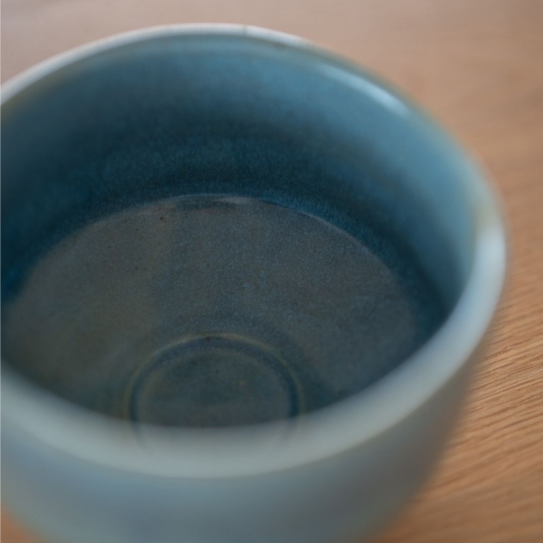 Tæt på dyb, tekstureret blå glasur inde i den håndlavede japanske matcha-skål "Summer Sky", der fremhæver Mino Ware's levende farve og wabi sabi-æstetik.