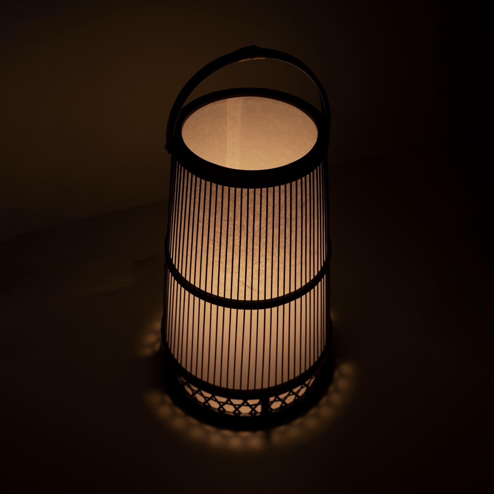 "Lampe japonaise fabriquée avec l'art du bambou de Shizuoka, vieux de 800 ans. De délicates lamelles de bambou créent des motifs complexes, diffusant une lumière chaude à travers le papier japonais."