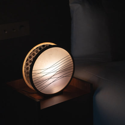Japanese bamboo table lamp on a bedside table in Japandi bedroom. 