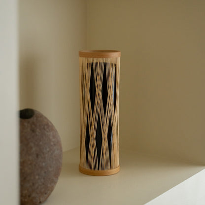 Japansk bambus blomstervase "Sammenflettede grene" på en hvid hylde - Stilfuld ikebana blomstervase med wabi-sabi æstetik